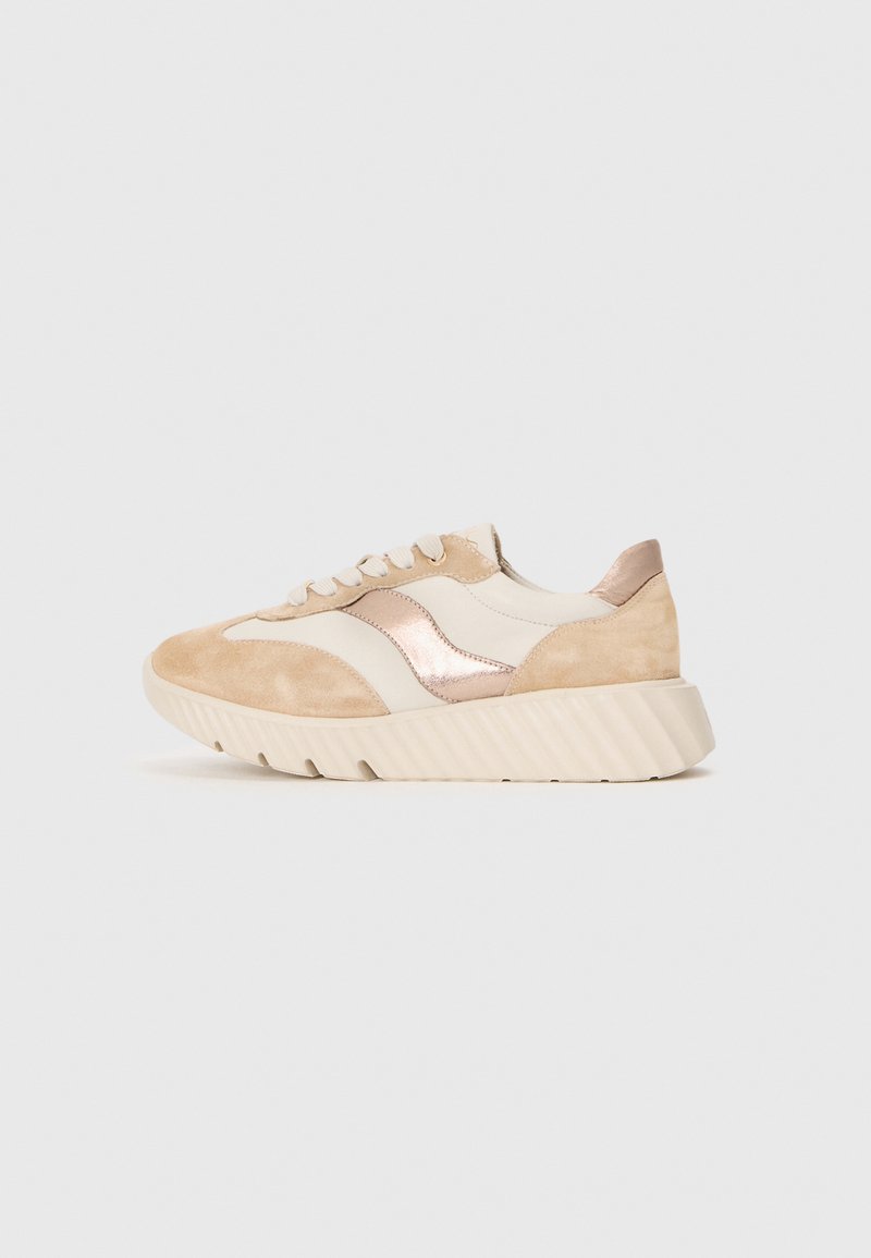 Sneaker beige e crema con dettagli in suede e metallizzati, dotata di una suola spessa e rigata, punta tondeggiante e strisce laterali in contrasto.