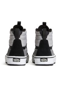 Zapatillas altas en ante gris y negro, con cuellos acolchados, suelas de goma blanca y detalles en negro, con el logo de la marca en el talón.