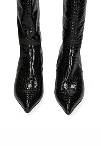 Stivali in pelle nera con imprinting coccodrillo, al ginocchio, con punta affusolata e finitura lucida. Presentano una silhouette elegante e senza hardware visibile.
