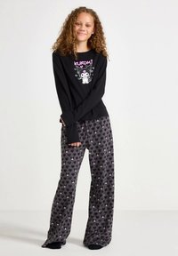 Long-sleeve black top with "Kuromi" graphic; gray pajama pants with pink and white heart patterns. Soft fabric and relaxed fit.