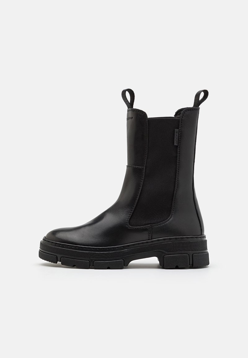 Botte noire mi-mollet en cuir avec panneaux latéraux élastiques, languettes à l'avant et à l'arrière, et semelle épaisse texturée pour une meilleure adhérence.