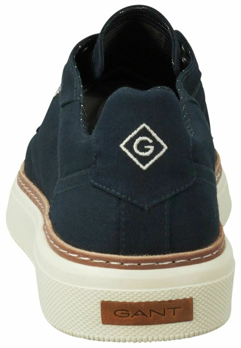 Marineblaue Canvas-Sneaker mit weißer Sohle, braunen Akzenten und Logo-Patch an der Ferse. Verfügt über gestickte Details entlang der Sohle und eine strukturierte Oberseite.