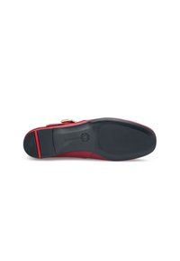 Mocassin en cuir rouge à bout arrondi, avec des accents en métal doré et une semelle texturée noire comportant un détail en stripe rouge.