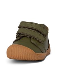 Scarpe verdi in pelle con doppie fibbie in velcro, suola in gomma marrone, punta arrotondata e dettagli testurizzati sulla parte superiore. Design casual.