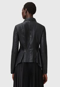 Schwarze Lederjacke mit taillierter Silhouette, langen Ärmeln und einem halbhohen Kragen. Verfügt über einen Peplum-Saum und eine glatte Textur.