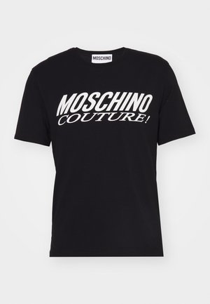 T-shirt en coton noir à manches courtes et col rond. Présente un texte blanc audacieux "MOSCHINO COUTURE !" sur le devant.