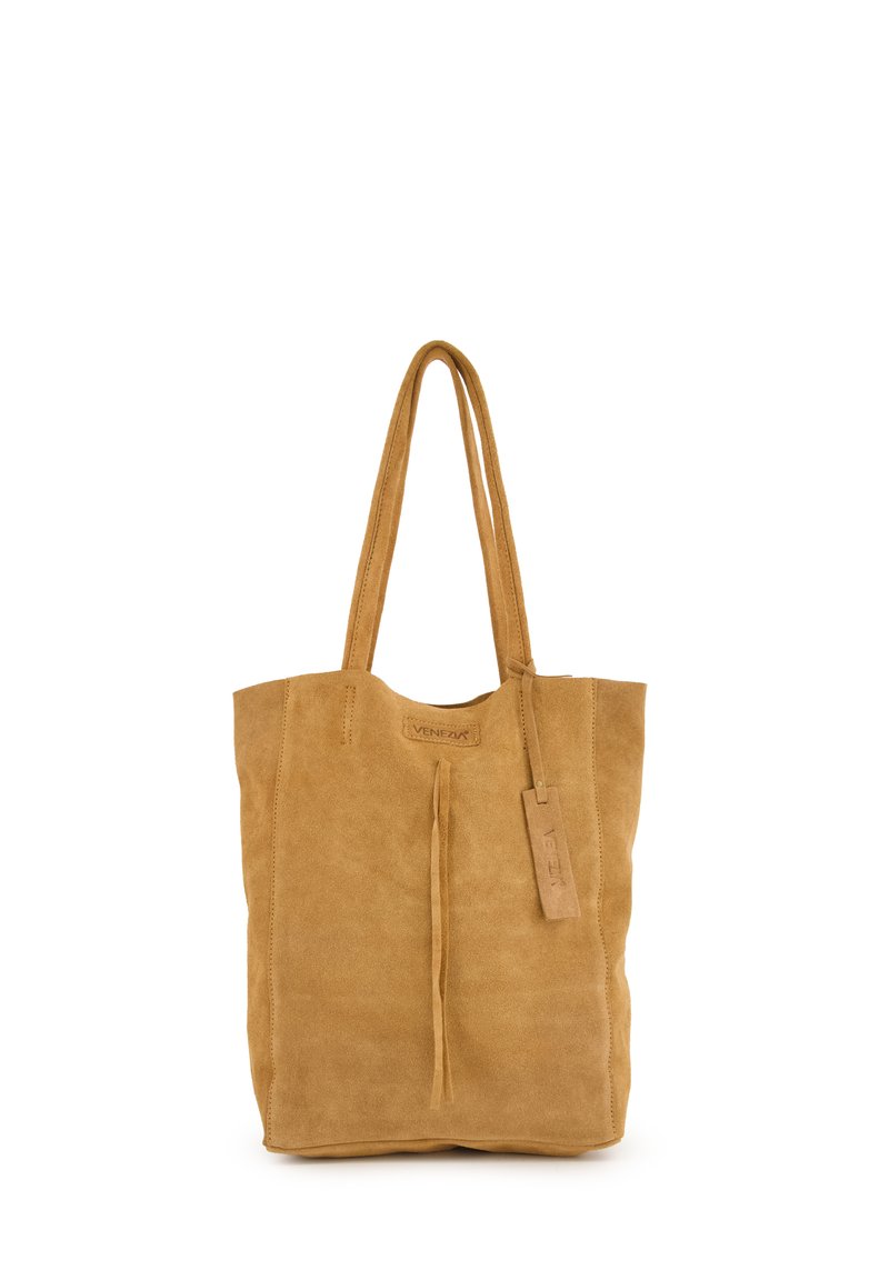 Beige Wildleder-Tasche mit einem schlichten Design, langen Henkeln, einem Fransen-Detail an der Vorderseite und einem Lederanhänger mit "Venezia"-Branding.