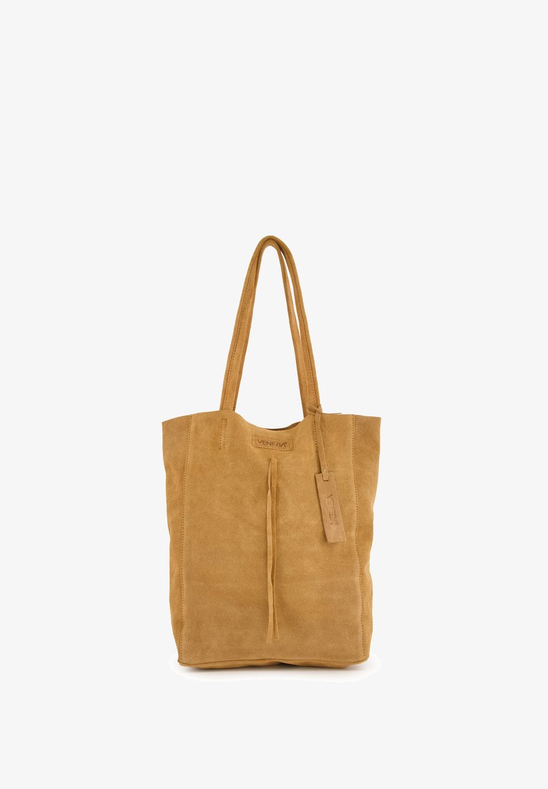 Tan suède tote bag met een eenvoudig ontwerp, verlengde handvaten, een voorste kwastdetail en een leren label met "Venezia" branding.