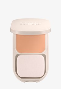 Base en polvo compacta de color beige con esponja aplicadora en una caja de color crema etiquetada "LAURA MERCIER" en la tapa.