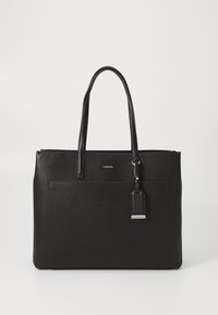 Sac cabas en cuir noir avec deux poignées, une poche avant et une petite étiquette attachée, posé sur un fond blanc uni.