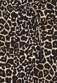 Tecido de padrão de leopardo em preto e bege, com fecho por cordão na cintura e textura suave. Inclui detalhes em cordão pretos.