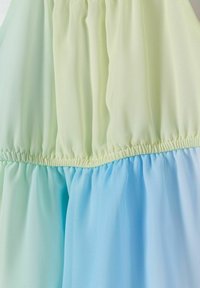 Pastelna obleka z nabranim korpusom in gradientnim dizajnom, ki prehaja iz svetlo zelene v svetlo modro, izdelana iz mehke, lahke tkanine.