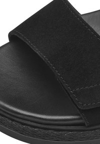 Černé semišové sklíčkové sandály s širokým páskem, texturovanou stélkou a hladkou podrážkou. Prošívání podél pásku vylepšuje design.