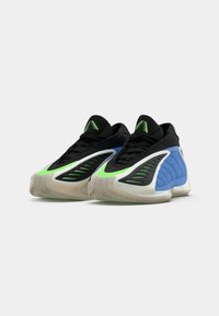 Zapatillas deportivas con una parte superior negra y detalles en verde y azul, paneles texturizados, un diseño ligero y una suela de goma con relieve.