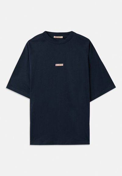 Marinblå t-shirt i bomull, med korta ärmar, rund halsringning och ett litet rödvitt logopatch på framsidan.