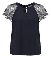 Blouse bleu marine avec des manches en dentelle, présentant un décolleté en forme de clé et une texture douce. Design élégant avec des détails en dentelle contrastée aux épaules.