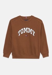 Sweatshirt en coton marron avec "TOMMY" en texte blanc en arc sur le devant, col, manches et poignets côtelés, et un petit logo sur la manche.