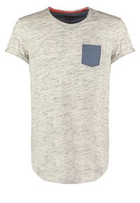 T-shirt a maniche corte grigio chiaro con delicate macchie nere e una tasca sul petto di colore blu a contrasto sul lato sinistro.