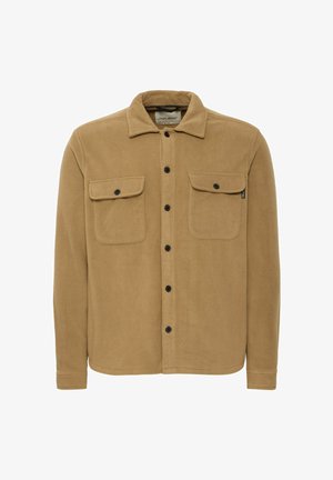 Tan fleece shirt jacket with a button-up front, two chest pockets, and a pointed collar. Features black buttons and a soft texture.