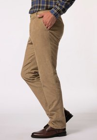 Bežové bavlněné chinos kalhoty s úzkým střihem, s bočními kapsami, plochým předním dílem a hladkou texturou, spárované s hnědými koženými botami.