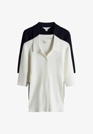 Zwei gerippte Strick-Poloshirts, eines weiß und eines schwarz, mit kurzen Ärmeln und Knopfleisten, übereinandergelegt vor einem weißen Hintergrund.