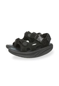 Sandalias negras con una suela negra gruesa y curvada, correas ajustables con hebillas y recortes para transpirabilidad, fabricadas con materiales duraderos.