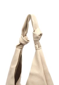 Bežna usnjena torba z vozlanimi ročaji. Teksturiran material se ponaša z mehkimi površinami in širokim odprtjem za dostop.