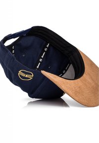 Navy blue cap with a cork brim, black inner lining, and a logo in yellow. Features stitched design and adjustable strap at the back.