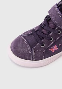 Fialové semišové tenisky s ružovým dizajnom motýľa, okrúly špička, šnurovanie a biela gumová podrážka s viditeľnými š stitching detailmi.