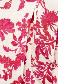 Tessuto floreale bianco con motivi rosa vibranti. Presenta grandi fiori audaci e foglie in varie tonalità, con una superficie testurizzata.