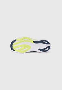 Shoe sole in white, bright yellow, and dark blue; features textured grip patterns and cut-out detailing for flexibility.