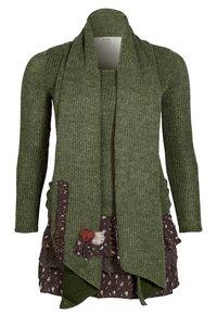 Cardigan verde lavorato a maglia con maniche lunghe, caratterizzato da un davanti a cascata, un motivo testurizzato e dettagli floreali su una gonna stratificata marrone.