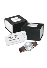 Montre argentée avec un bracelet en cuir marron, design minimaliste, chiffres arabes et boîtier rond ; accompagnée de boîtes-cadeaux noires et d'une carte de garantie.