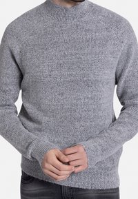 Grauer Strickpullover mit einem hohen Kragen, gerippten Bündchen und strukturiertem Muster. Verfügt über ein tailliertes Design und weichen, dehnbaren Stoff.