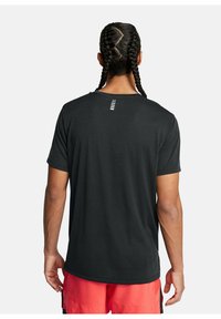 Camiseta negra de manga corta con cuello redondo, que presenta una fila vertical de acentos blancos en la espalda. Textura suave, ajuste relajado.