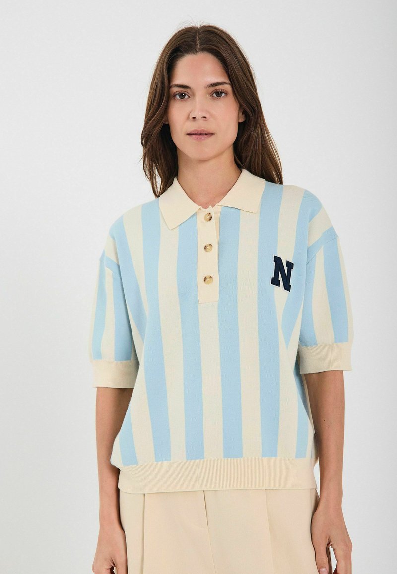 Heledad sinine ja kreemjas triibuline lühikese varrukaga polo, millel on kolm nuppu, kaelus ja tikitud täht 'N' detail rinnal.