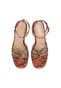 Riemchensandalen mit einem Schlangenhautmuster in Orange und Schwarz. Verfügt über eine flache Sohle und dekorative geflochtene Details. Verstellbarer Knöchelriemen.