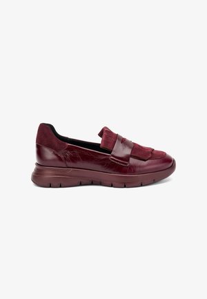 Zapatos slip-on burdeos con materiales de cuero y gamuza, que presentan una suela gruesa, acentos de borlas y una textura suave.
