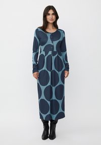 Abito da donna a maniche lunghe, con bottoni, di colore teal con grandi cerchi navy, caratterizzato da una gonna arricciata e un collo rotondo. Tessuto morbido ed elastico.