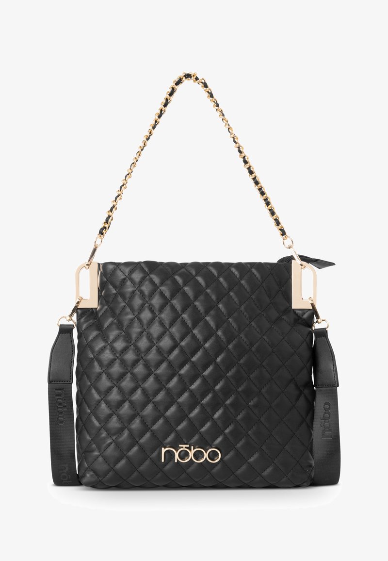 Mustakvadratinen käsilaukku kultaketjun olkahihnalla ja kultaisin varustein. Ominaisuuksiin kuuluu sileä pinta ja logotehoste edessä.