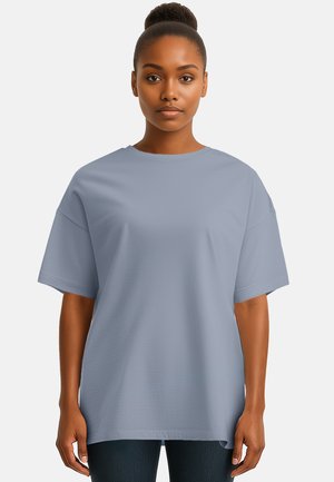 T-shirt oversize azzurro chiaro con maniche corte, scollatura rotonda e texture in cotone morbida. Nessun motivo o accento visibile.