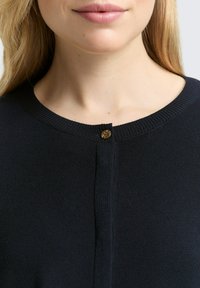 Marineblauwe cardigan met een ronde ribbelkraag, voorzien van een gouden knoopsluiting bij de hals en een zachte, gestructureerde brei.
