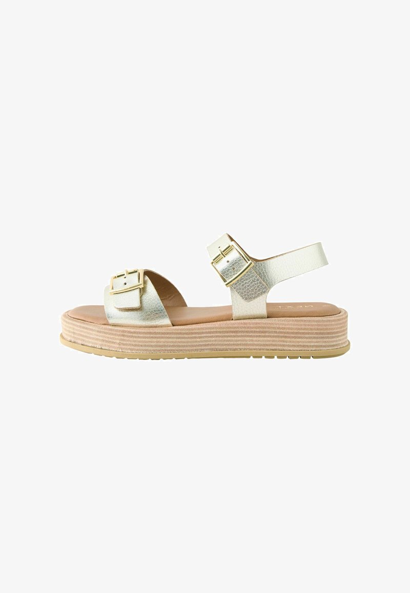 Strappy platform sandal in metallic light gold with two square buckles and a textured upper, featuring a layered cork sole and rubber outsole.
