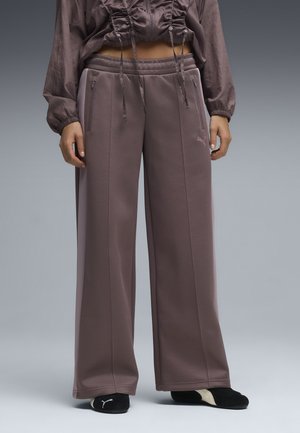 Bredde sportsbukser i en dæmpet mauve farve med et glat materiale, elastisk waistband, sidelommer og kontrasterende trimdetaljer.