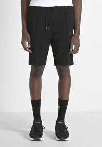 Pantaloni sportivi neri con cintura elastica e lacci, caratterizzati da due pieghe frontali e un sottile dettaglio del logo sul lato.