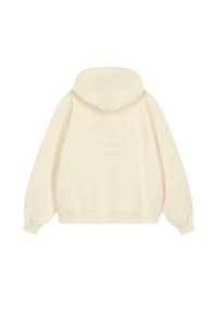 Sudadera color crema con un corte holgado, que presenta una impresión texturada en la parte posterior que dice "CHASING THE SUN" y "EST. 2018". Tela suave.