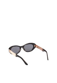 Katteøje-solbriller med sorte stel, mørke linser og guld-besatte arme. Glat tekstur med et moderne og strømlinet design.