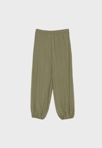 Pantalon vert olive ample avec taille élastique et poignets élastiques froncés sur un fond clair uni.