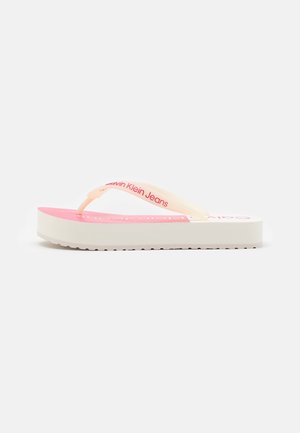 Lyserød og hvid platform-flip-flop med cremefarvede stropper med rød "Calvin Klein Jeans"-branding på hvid baggrund.