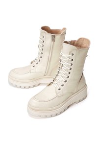 Bottes en cuir crème à lacets avec une fermeture éclair sur le côté, finition texturée, bout rond et une semelle épaisse et chunky avec un motif de treads robuste.